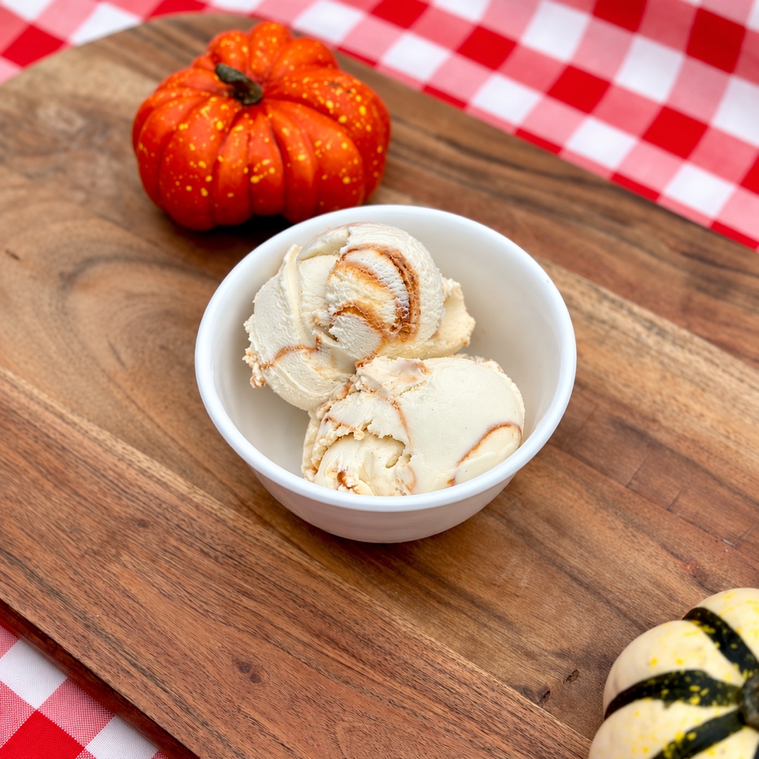 Vanilla Salted Caramel Ice Cream Vanilla salted caramel ice cream with caramel swirls in a white bowl on a wooden board.